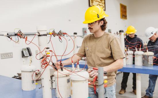 An electrical line worker student conducting a lab test